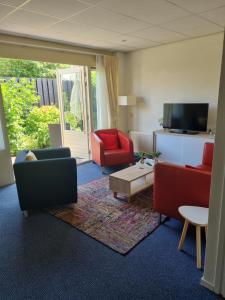 een woonkamer met rode stoelen en een tv bij Hotel Lemmer in Lemmer