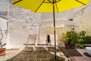 two chairs and a yellow umbrella on a patio at Casa Vacanze Cattedrale in Ostuni