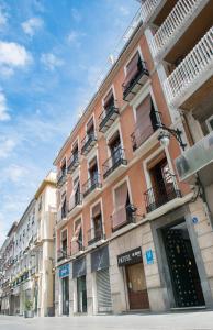 een hoog roze gebouw met balkons in een straat bij Las Nieves in Granada