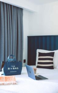 a blue bag sitting on top of a bed with a laptop at Aphrodite Hotel Kaş in Kas