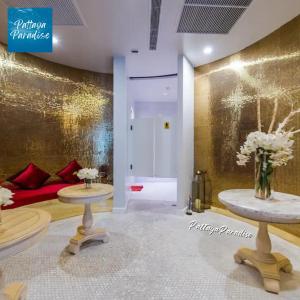 - un salon avec un canapé rouge et 2 tables dans l'établissement Espana Hotel Jomtien Beach Pattaya, à Jomtien Beach