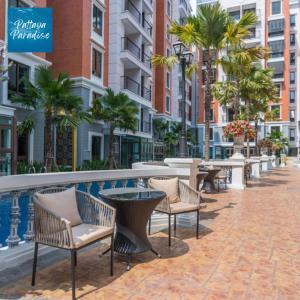 un patio avec chaises et tables et une piscine dans l'établissement Espana Hotel Jomtien Beach Pattaya, à Jomtien Beach 152 autres photos