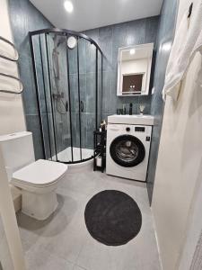 a bathroom with a shower and a washing machine at Ogre City Apartments in Ogre