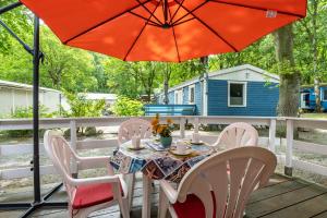 a table and chairs with an umbrella on a deck at Bungalow Uschi - Bgl 29 in Dranske