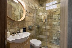 a bathroom with a toilet and a sink and a shower at Aurora Premium Hospitality in Parga +176 photos