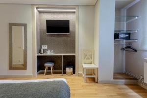 1 dormitorio con 1 cama y TV en la pared en Hostal Rodas Pamplona, en Pamplona