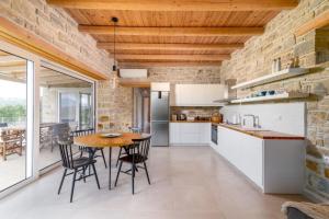 - une cuisine avec un plafond en bois, une table et des chaises dans l'établissement Nature Villa Yasemi, à Kamilárion
