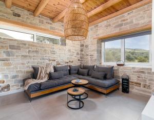 un salon avec un canapé et un mur en pierre dans l'établissement Nature Villa Yasemi, à Kamilárion