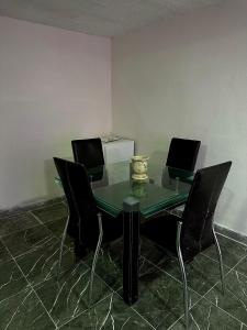 a glass table with black chairs in an empty room at Alborada 2 Cerca del Aeropuerto in Mexico City +2 photos