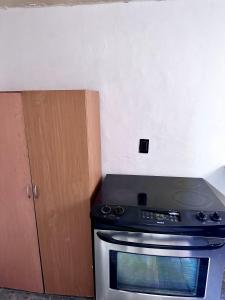 a stove top oven in a kitchen next to a cabinet at Alborada 2 Cerca del Aeropuerto in Mexico City