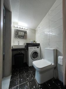 a bathroom with a toilet and a sink and a washing machine at Mariam Apartment in Nea Moudania