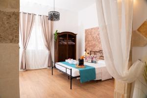 Un dormitorio con una cama con una mesa y una ventana. en Il Varco Antico, en Brindisi