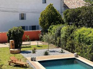 een tuin met een bank en een zwembad bij Gîte l'atelier de Phil et Delfe in Sainte-Cécile-les-Vignes