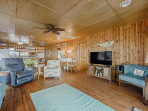 a living room with a television and a couch and chairs at Seahorse Sound in Topsail Beach