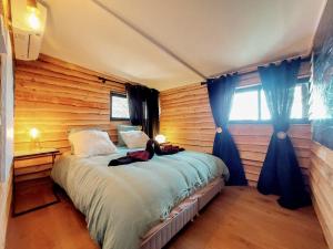 ル・カステレにあるChalet, Oasis et vue mer,proxi circuit Paul Ricardのベッドルーム1室(ベッド1台、女性1名が座るベッド1台付)