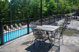 a table and chairs sitting next to a pool at Easy-Access Pigeon Forge Cabin with Hot Tub! in Pigeon Forge