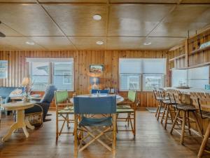 a dining room with wooden walls and tables and chairs at Seahorse Sound in Topsail Beach