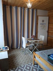a room with a table and chairs and curtains at CHAMBRE LA NOE in Saint-Cast-le-Guildo