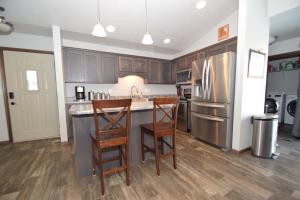 Una cocina con gabinetes de madera y un refrigerador de acero inoxidable. en The Harrisburg Hideaway, en Harrisburg 5 fotos más