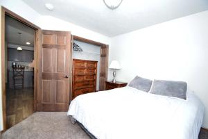 1 dormitorio con cama blanca y puerta en The Harrisburg Hideaway, en Harrisburg