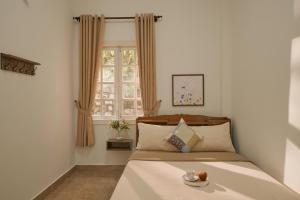 a bedroom with a bed and a window at Oliu Home Đà Lạt in Xuan An