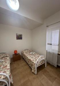 una camera da letto con due letti e una finestra di Casa Vacanza Ginevra a Ravello