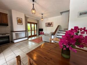 a living room with a vase of flowers on a table at Villa Nāos - ADAMOS HOLIDAYS in Skala Fourkas
