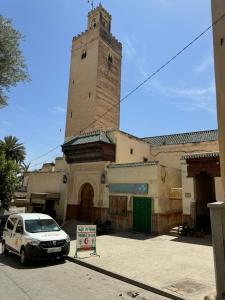 a car parked in front of a building with a tower at Center Medina in Fez