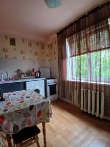 a small kitchen with a table and a stove at Квартира на Дегтярёвской in Kyiv