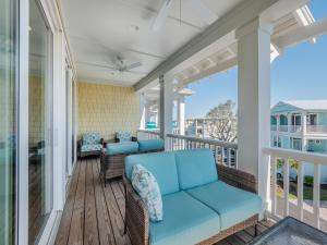 a porch with a couch and chairs on a balcony at Serenity By the Sea in Kure Beach