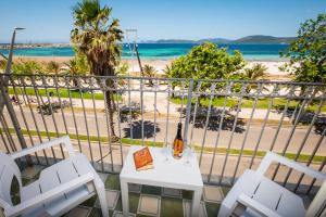 a bottle of wine on a table on a balcony with the beach at Hotel Il Gabbiano in Alghero