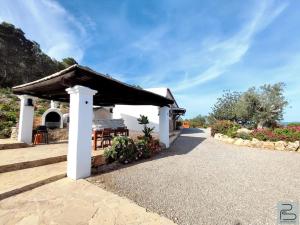 a pavilion at a resort with a table and chairs at Casa Can Lluc con piscina, jardín y vista al campo in Sant Miquel de Balansat