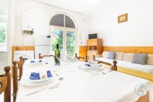 a dining room with a table and a couch at Villetta a schiera nella Pineta di Silvi Marina in Silvi Marina