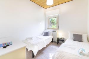 a bedroom with two beds and a window at Villetta a schiera nella Pineta di Silvi Marina in Silvi Marina