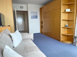 a living room with a couch and a tv at Frische Brise FeWo 09 08 in Cuxhaven