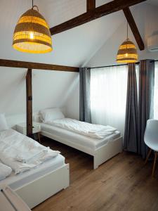 two beds in a room with two windows at Casa Gherman Cheia in Cheia