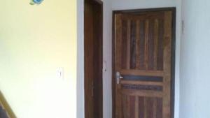 una puerta de madera en una habitación con pasillo en Chalé do Saulo, en Ilhabela