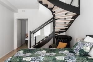- une chambre avec un lit et un escalier dans l'établissement Loft Itäpuisto By Borg Housing, à Pori