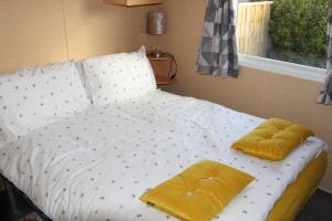 キャメルフォードにあるRetreat static caravanの寝室に枕が2つ置かれたベッド