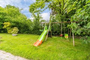 a playground with a slide in a yard at Chez Papitou - Escapade Familiale en Bretagne in Saint-Adrien