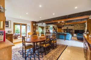 a dining room and living room with a table and chairs at Chez Papitou - Escapade Familiale en Bretagne in Saint-Adrien