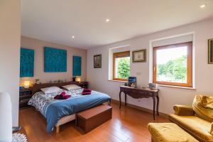 a bedroom with a bed and a table and a couch at Chez Papitou - Escapade Familiale en Bretagne in Saint-Adrien +19 photos