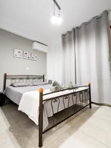 1 dormitorio con 1 cama con sábanas blancas y cortina en Ofrynio Luxury Apartments & Pool, en Ofrinion