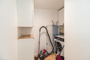 a kitchen with a vacuum and a washing machine at Charmante maison neuve avec terrasse Port du Legue in Plérin +12 photos