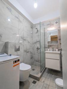 Un baño con ducha, inodoro y lavabo. en Ofrynio Luxury Apartments & Pool, en Ofrinion