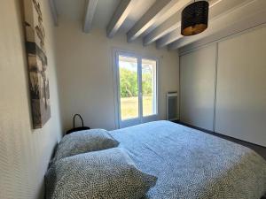 a bedroom with a bed and a window at DUNES - Villa Patio Avec Jardin - proche Plage de la Gravière in Soorts-Hossegor