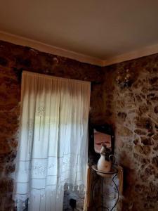 a room with a window with a white curtain at Can Catalina in Terrades