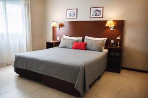 um quarto com uma cama grande e uma almofada vermelha em DonSuites em Corrientes