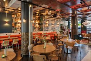 - un restaurant avec des tables et des chaises dans une salle dans l'établissement Generator Berlin Alexanderplatz, à Berlin