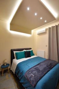 a bedroom with a bed with blue sheets and a window at Eugenia's Luxury Apart in Volos